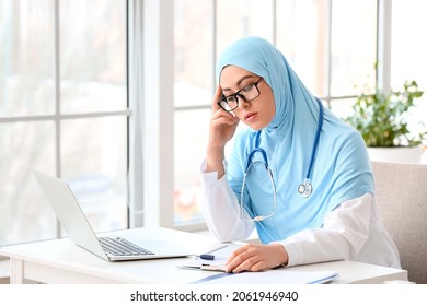 Tired Muslim female doctor working in clinic - Powered by Shutterstock