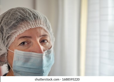 Tired Nurse Doctor In Protective Mask And Cap Against Coronavirus Type Covid 19. Close-up.