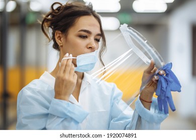 Tired Nurse Takes Off A Protective Face Shield And Medical Mask After A Tough Working Shift At The Hospital. Female Doctor Fights The Coronavirus Pandemic Working Hard Overtime And Being Exhausted