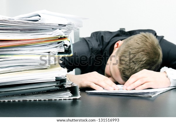 tired office worker\
and a pile of documents