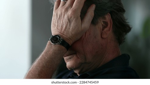 Tired older man yawning and rubbing face with hands. Pensive senior person feeling exhausted - Powered by Shutterstock