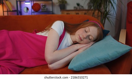 Tired One Girl Child Lying Down In Bed Taking A Rest At Home. Carefree Young Teen Redhead Children Kid Napping, Falling Asleep On Comfortable Sofa With Pillows. Closed Her Eyes Enjoy Daytime Nap Alone