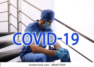 Tired Overwhelmed Doctor Sitting On Stairs In Hospital. Medical System Collapse During Coronavirus Pandemic