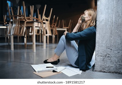 Tired owner sitting on floor in closed cafe, small business lockdown due to coronavirus. - Shutterstock ID 1891581217
