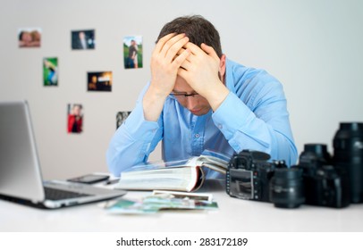 Tired Photographer Working At His Workplace.