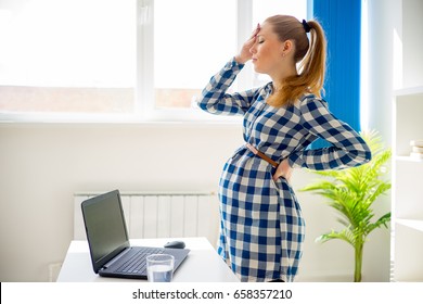 Tired Pregnant Woman Working In Office