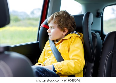 Tired Preschool Kid Boy Sitting In Car During Traffic Jam. Sad Little School Child In Safety Car Seat With Belt Enjoying Trip And Journey. Safe Travel With Kids And Traffic Laws Concept.