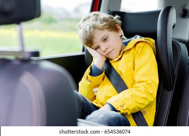 Tired Preschool Kid Boy Sitting In Car During Traffic Jam. Sad Little School Child In Safety Car Seat With Belt Enjoying Trip And Journey. Safe Travel With Kids And Traffic Laws Concept.