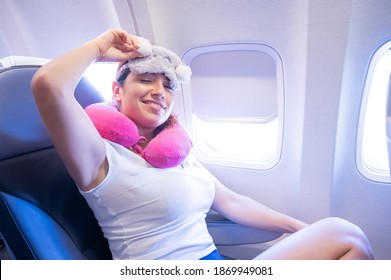 Tired Red-haired Woman Sleeping On The Plane With An Eye Mask And A Neck Pillow