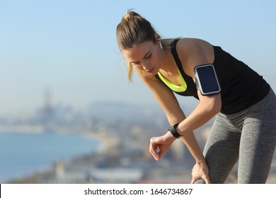 Tired runner checking smartwatch controlling pulsations after exercise - Powered by Shutterstock