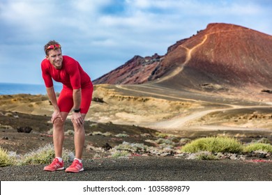 Tired runner on trail run feeling exhausted and dehydrated from the heat. Athlete man with smartwatch taking a break catching his breath looking at challenge ahead. - Shutterstock ID 1035889879
