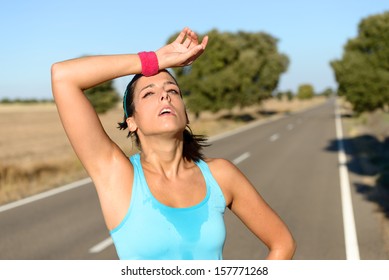 Tired Runner Sweating After Running Hard In Countryside Road. Exhausted Sweaty Woman After Marathon Training On Hot Summer. Hispanic Brunette Female Athlete Outdoors.