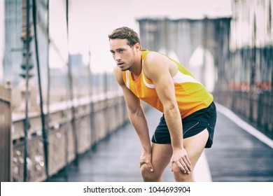 Tired runner taking a break breathing during jogging workout training on Brooklyn bridge in New York City, NYC active healthy lifestyle. Man running outdoors. - Powered by Shutterstock