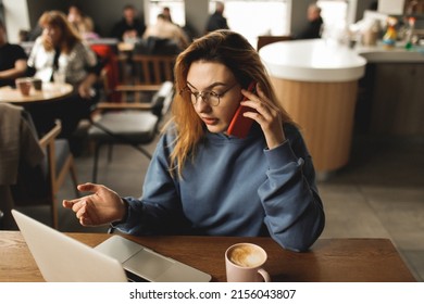 Tired Sad Woman With Glasses Working In The Cafe. Feeling Mental Illness And Stress After Overwork. Freelance Girl Working In A Cafe. The Girl Works Remotely. Work Remotely. Online Learning. Remote.