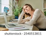 Tired sad young student woman sitting at home at desk with computer