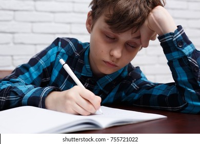 Tired schoolboy falling asleep while studying at copybook. Studying difficulties, education, homework concept - Powered by Shutterstock