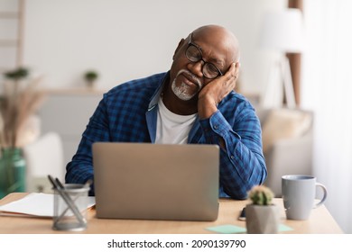 Tired Senior Black Man Sleeping At Laptop Sitting With Eyes Closed, Napping At Workplace In Modern Office. Sleeplessness, Health Problems, Lack Of Sleep Concept.