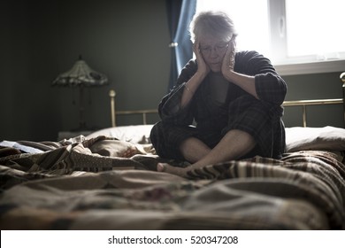 A Tired Senior Woman On Her Bed