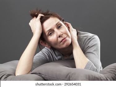 Tired Senior Woman Resting Her Face And Hands Laying Down On Cushions For Comfort And Relaxation