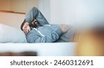 Tired, sleep and man in bed with stress, burnout and mental health rest in home, apartment or hotel. Fatigue, insomnia and person with depression, anxiety or headache in bedroom to relax in morning