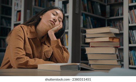 Tired sleepy asian woman student fall asleep in university library exhausted drowsy girl sleeping on desk with stack books feel fatigue doze sleep on table break from studying exam preparation concept - Powered by Shutterstock