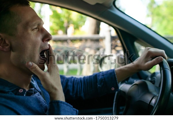 Tired Sleepy\
Man Or Driver Driving Car And\
Yawning