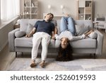 Tired sleepy silent young husband and wife resting on sofa upside down, relaxing on grey comfortable soft couch, enjoying leisure time, break, home comfort, relaxation