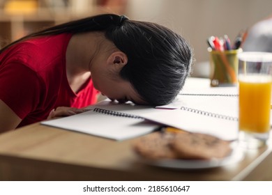 Tired Sleepy Young Chinese Lady Student Lies And Sleeps On Table With Notebooks In Room Interior, Close Up. Stress, Fatigue, Overwork And Problems With Study At Home, Knowledge And Preparing For