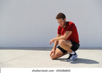 Tired sport fitness man exhausted breathing after difficult workout outdoors. Heat exhaustion athlete dehydrated or runner with knee injury pain resting in disappointment. - Powered by Shutterstock