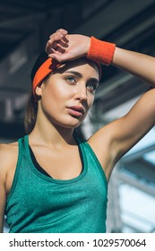 Tired Sporty Woman With Hand On Forehead At Gym