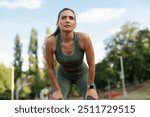 Tired sporty woman resting after running on athlete track