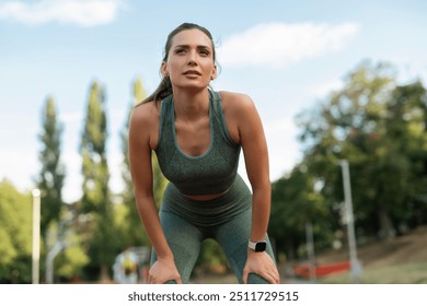 Tired sporty woman resting after running on athlete track - Powered by Shutterstock