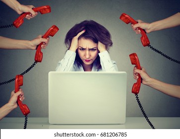 Tired Stressed Business Woman Working On A Laptop Overwhelmed By Too Many Phone Calls In Her Office 