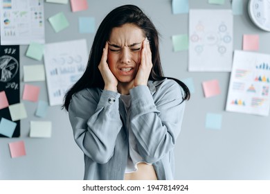 Tired stressed businesswoman feeling strong headache massaging temples exhausted from overwork, fatigued overwhelmed lady. Executive worker suffering from pain in head or chronic migraine in office - Powered by Shutterstock