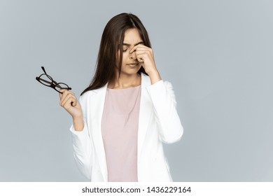 Tired Stressed Indian Business Woman Feeling Headache Dry Eye Strain Holding Glasses Isolated On Grey Studio Background, Upset Fatigued Hindu Girl Take Off Eyewear Having Bad Vision Problem Concept