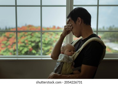 A tired stressed out father holding his sleeping baby at home. Postpartum depression. - Powered by Shutterstock