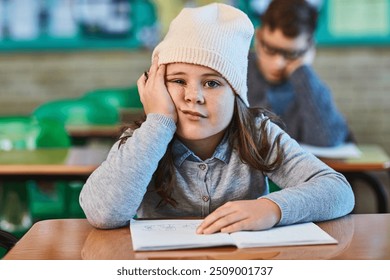 Tired, student and portrait of bored kid in classroom for education, learning and lazy. Child, fatigue and face of girl in elementary school with adhd, exhausted or low motivation with stress and sad