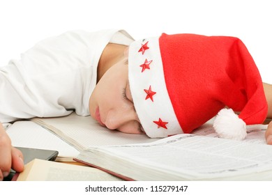 Tired Student In Santa's Hat Sleeping On School Desk After Hard Work For Exam