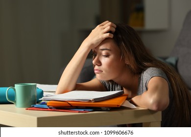 Tired student trying to study in the night at home - Shutterstock ID 1099606676