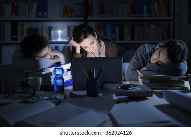 Des étudiants fatigués qui étudient tard dans la nuit, ils dorment sur le bureau et s'appuient sur des piles de livres
