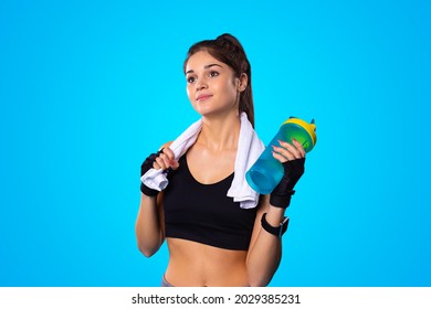 Tired Sweaty Wet Woman With A Towel After Fitness Workout In The Gym Holding A Bottle Of Water To Drink.