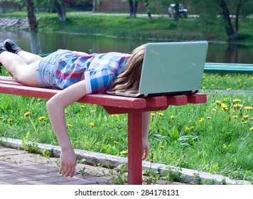 Tired Teen Girl Is A Summer Day On The Bench, His Face Buried In A Notebook