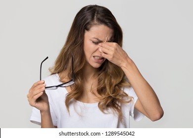 Tired Teen Girl Taking Off Glasses Rubbing Eyes Isolated On White Blank Studio Wall Background, Young Fatigued Woman Feeling Dry Irritable Eye Strain, Bad Blurry Vision Problem Tension Concept