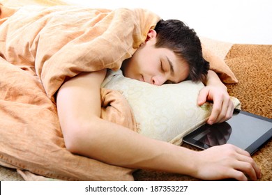 Tired Teenager Sleeping On The Bed With Tablet Computer