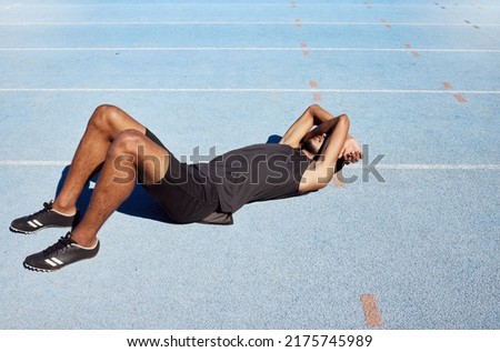 Tired track athlete lying down and feeling exhausted. Active, fit, competitive runner suffering from burnout, heatstroke in training exercise and workout practice. Man covering his face with his arms