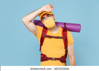 Tired traveler young man in yellow casual t-shirt face mask cap with backpack isolated on blue background. Tourist traveling on weekend getaway. Tourism discovering hiking concept. Put hand on head - Powered by Shutterstock