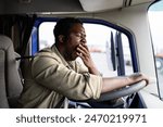 Tired truck driver feeling sleepy and yawning while driving.
