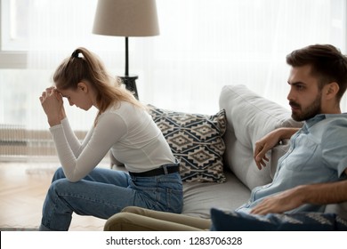 Tired Unhappy Couple Sitting Apart On Couch Not Talking Ignoring Apology After Fight At Home Feeling Empty Sad Frustrated, Upset Husband And Wife Fed Up With Problem Disagreement In Bad Relationship