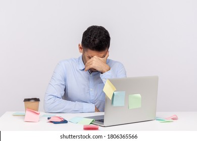 Tired unhappy man employee sitting in office workplace with sticky notes all around, bowing head crying, hiding face feeling depressed frustrated, upset about deadline. indoor studio shot isolated - Powered by Shutterstock