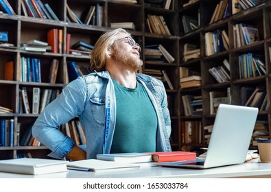 Tired Upset Young Man Teacher Student Sit At Office Home Library Desk Stretching Feel Back Pain Ache In Spine Need Rest After Work Study On Uncomfortable Chair, Fibromyalgia Backache Backpain Concept